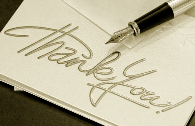 card reading "thank you" with a fountain pen resting on it