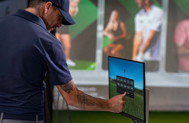 Man uses computer screen at X Golf.