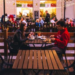 A man and a woman have dinner outside at a restaurant.