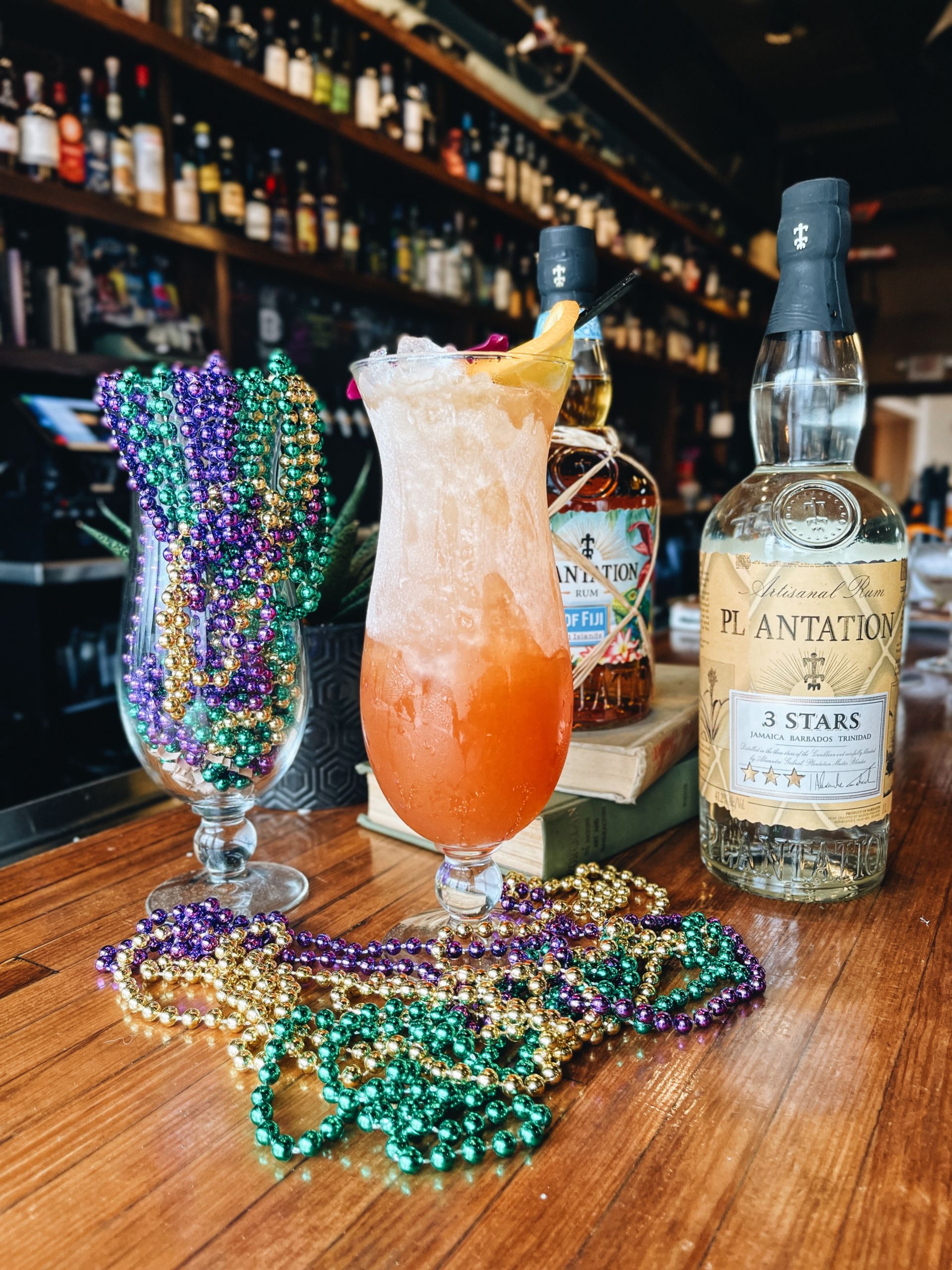 Amelia's Hurricane cocktail displayed next to a glass filled with beads
