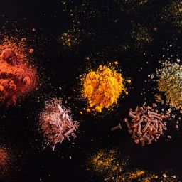 Multiple spices displayed on a black background.