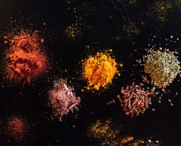 Multiple spices displayed on a black background.