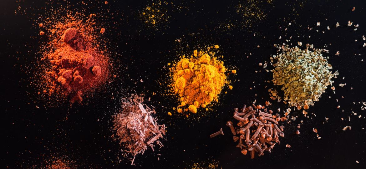 Multiple spices displayed on a black background.