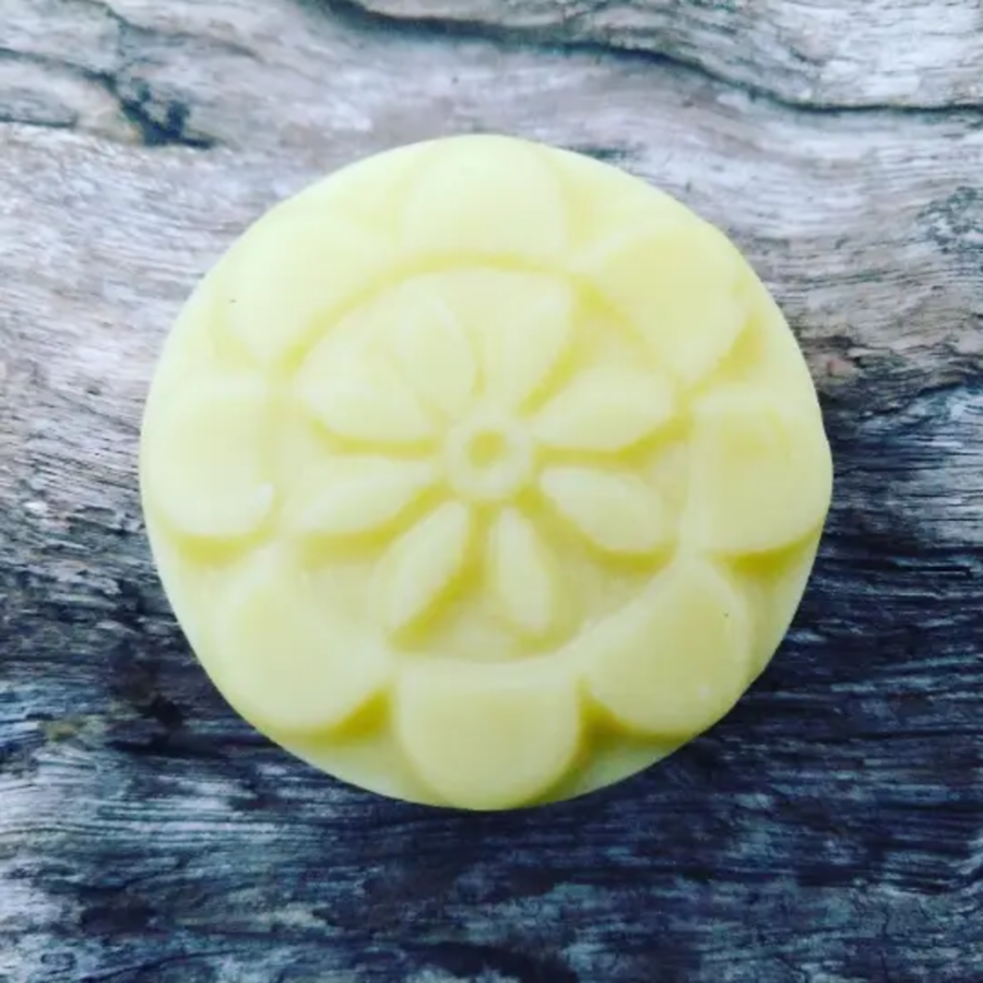 Yellow circular lotion bar with floral carving