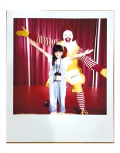 Little girl with Ronald McDonald with a red backdrop