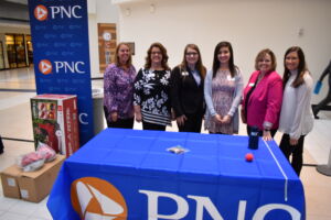Volunteers standing behind a PNC booth. 