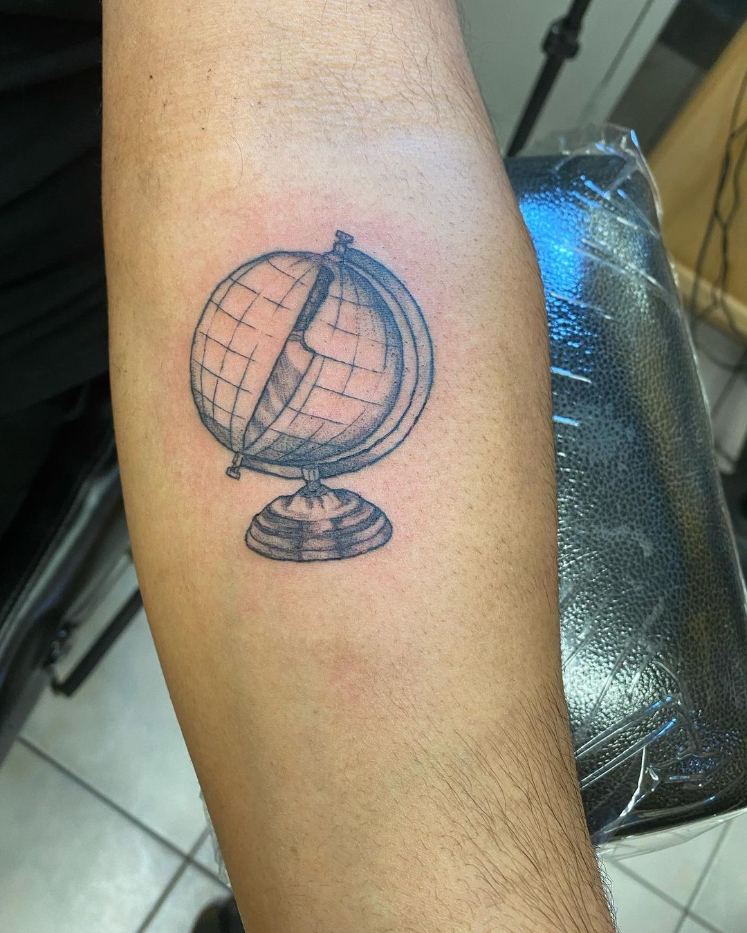Tattoo of a globe by Haley Dillon