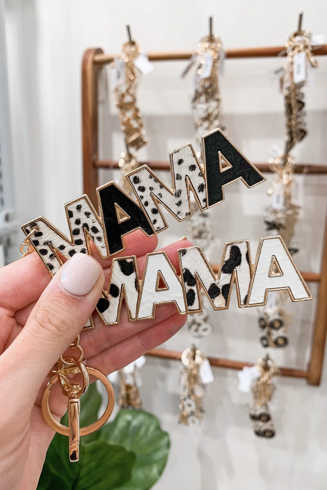 Hand holding an animal print keychain with the word "Mama" on it.