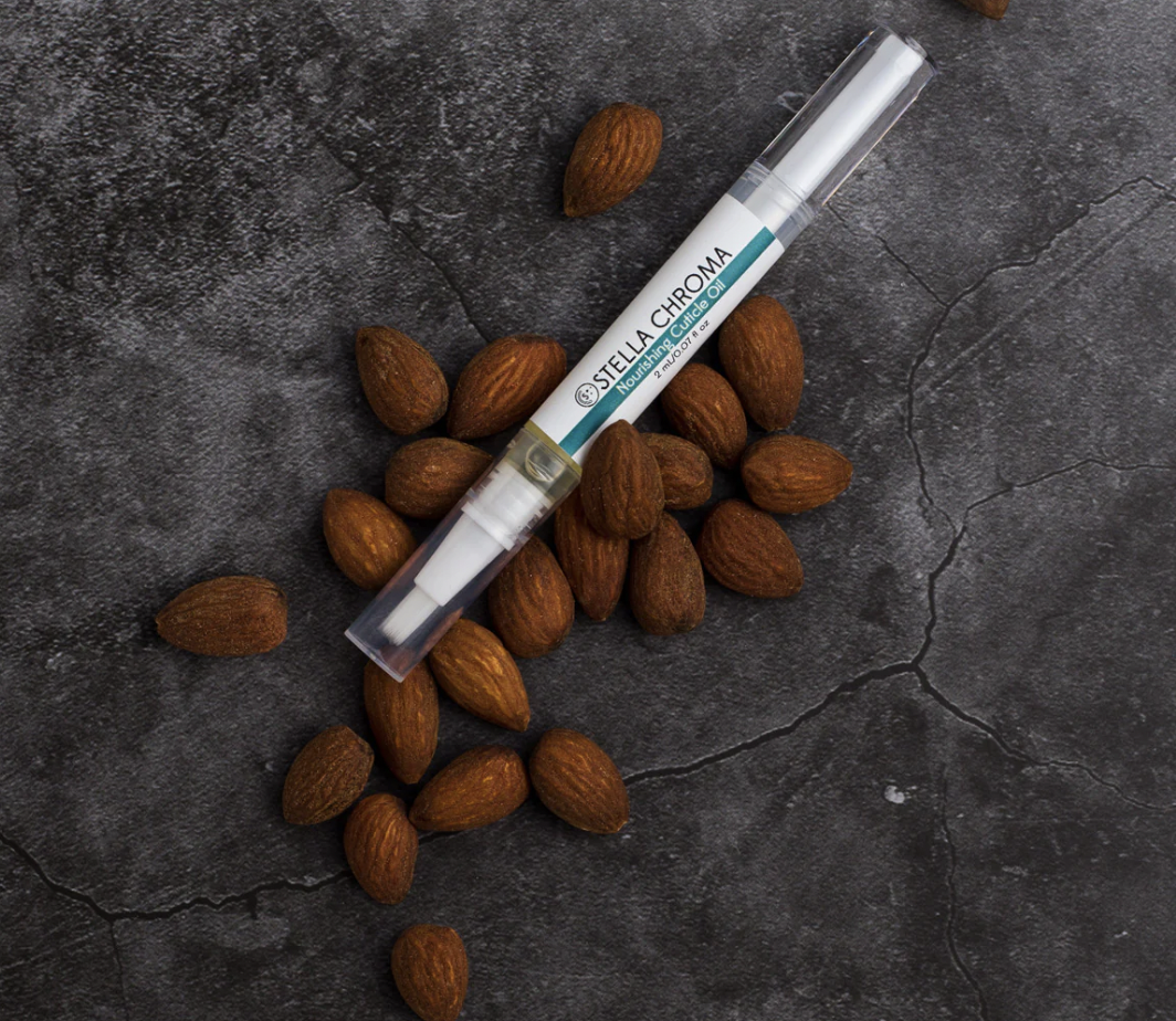 Nourishing Cuticle Oil surrounded by almonds