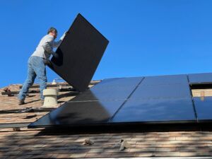 Guy applying solar panels to a roof 