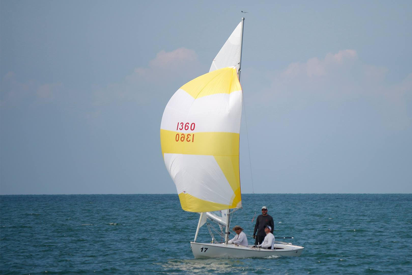 Yellow and white sailboat on the water