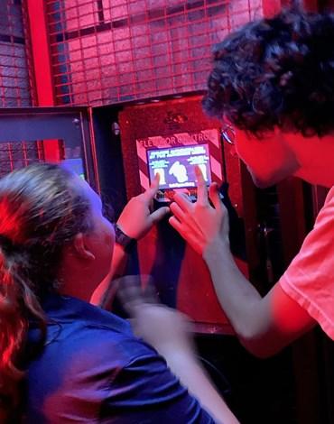People in escape room with red lights