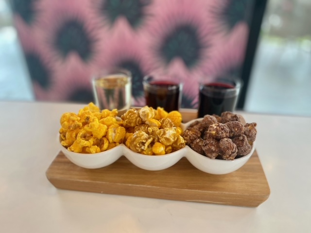 Wooden board displaying popcorn and wine. Photo provided by Just Pop In!
