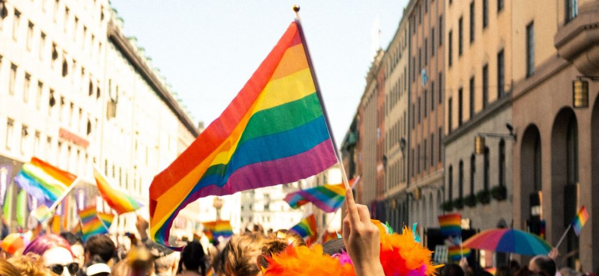 People marching down a street holding rainbow flags