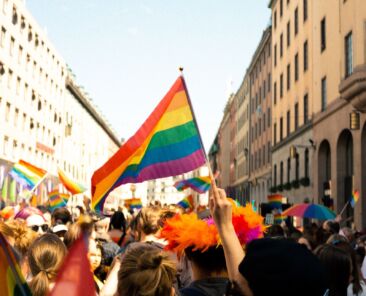 People marching down a street holding rainbow flags