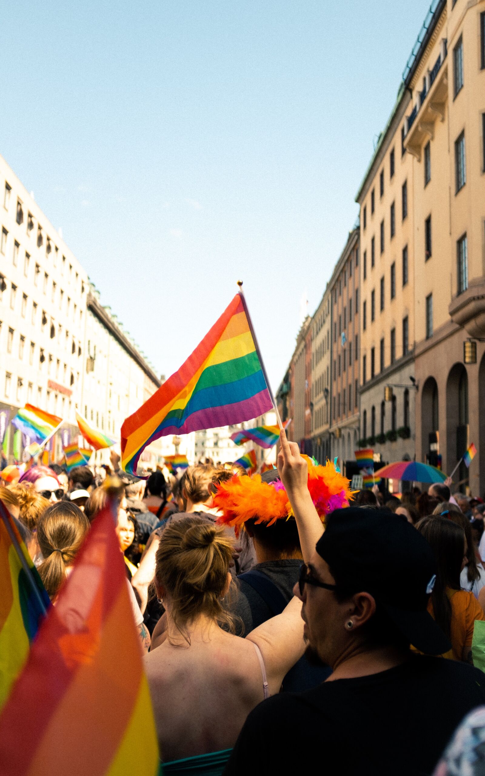 People marching down a street holding rainbow flags