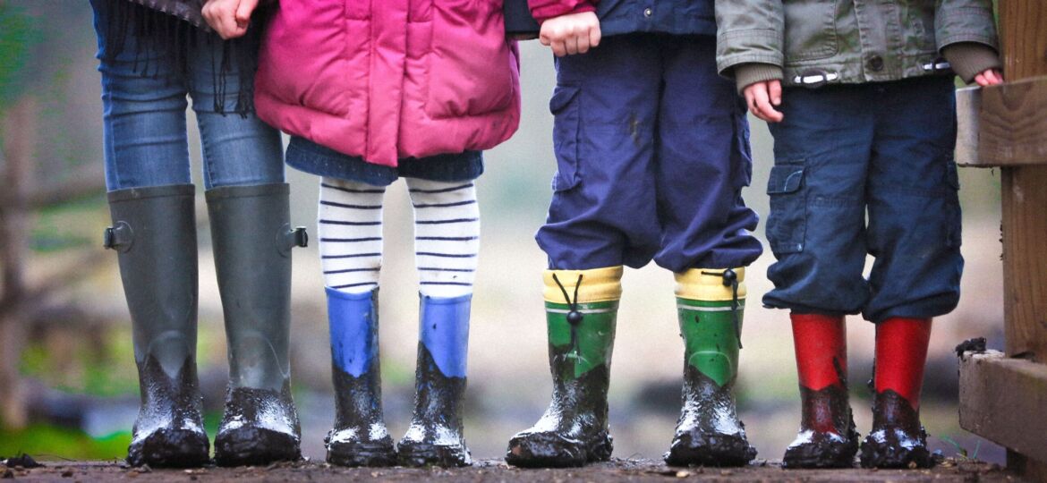 Line up up children in rain boots of different colors
