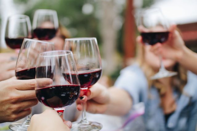 People clinking their wine glasses