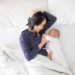 Mother and baby laying in bed together