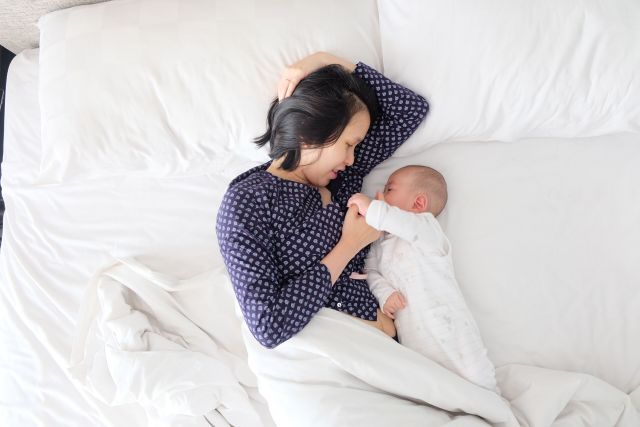 Mother and baby laying in bed together