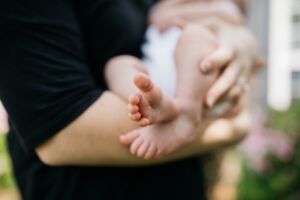 Man holding baby focused on baby feet 