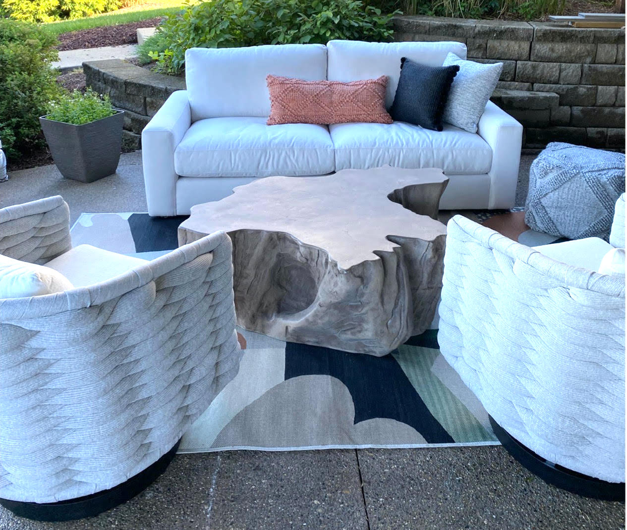 Three outdoor couches with a rug under them