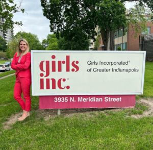 Gramlich posing in front of Girls Inc. sign