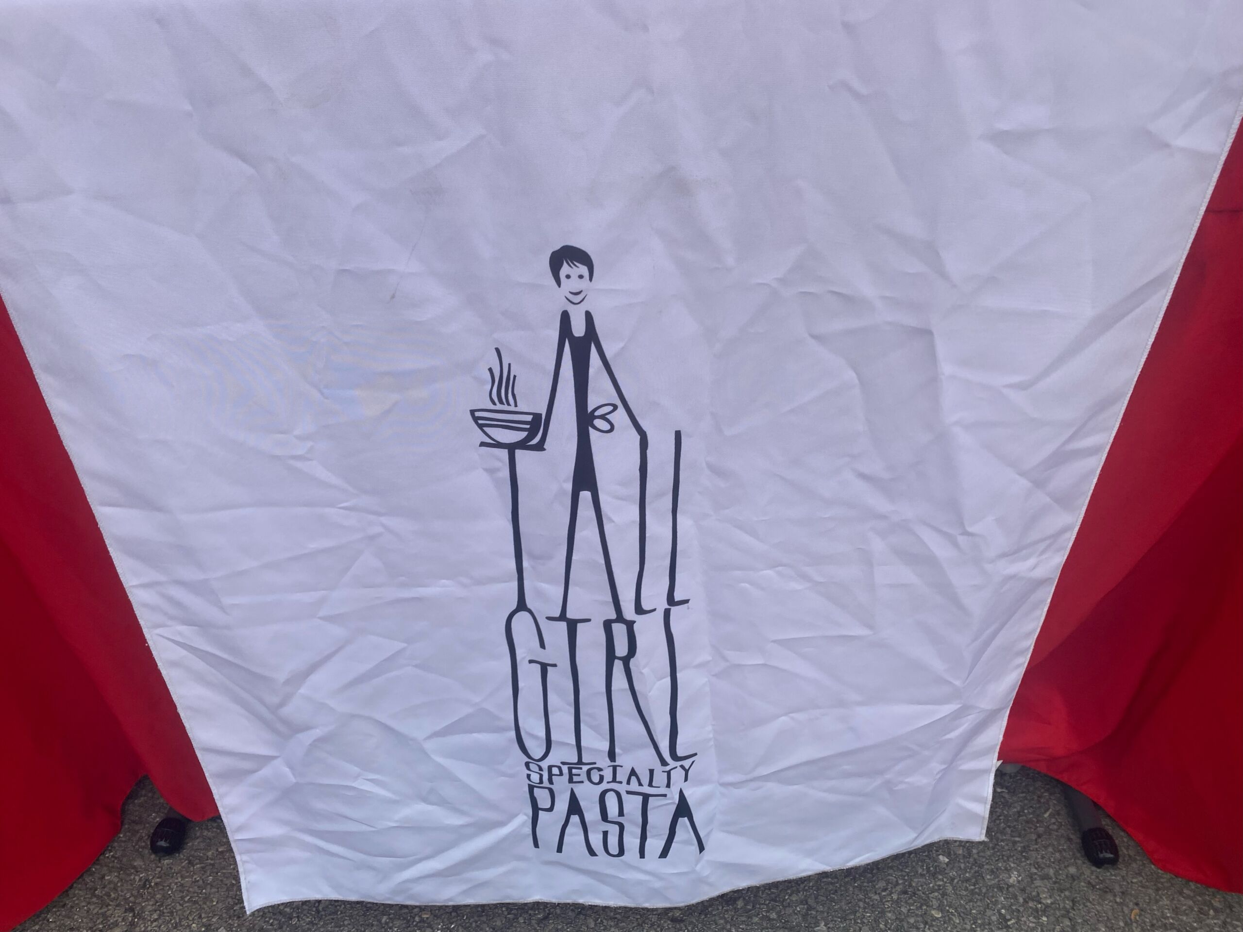 Table cloth that says "tall girl specialty pasta"