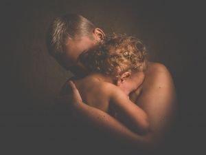 person holding baby to their chest 