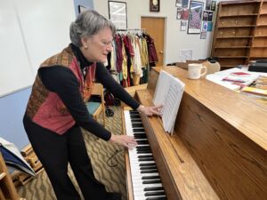 Robin Hess finds some notes at the piano for the Threshold Singers team members rehearsing at Allisonville Christian Church. Hess started singing with a Threshold choir since 2010. 
