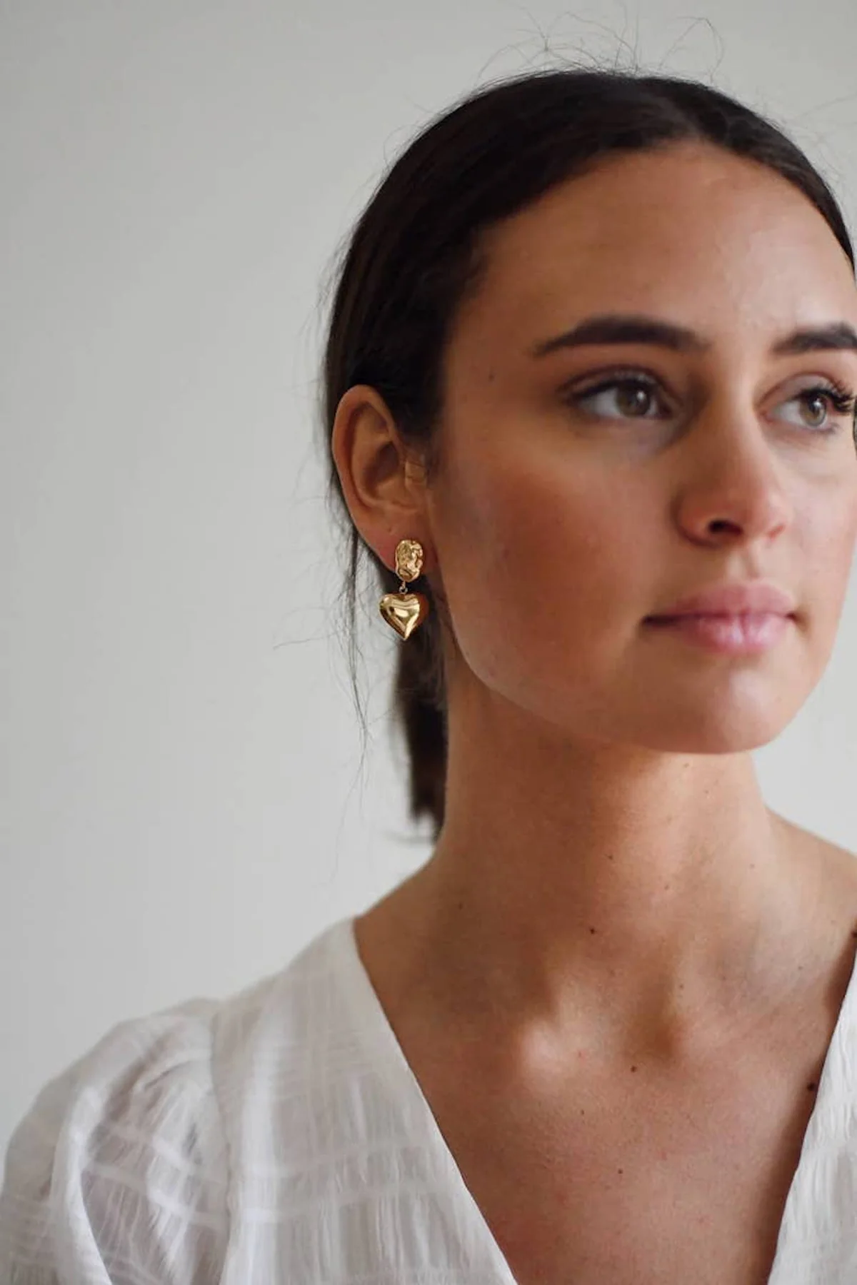 Model wearing Lilly and Sparrow heart earrings