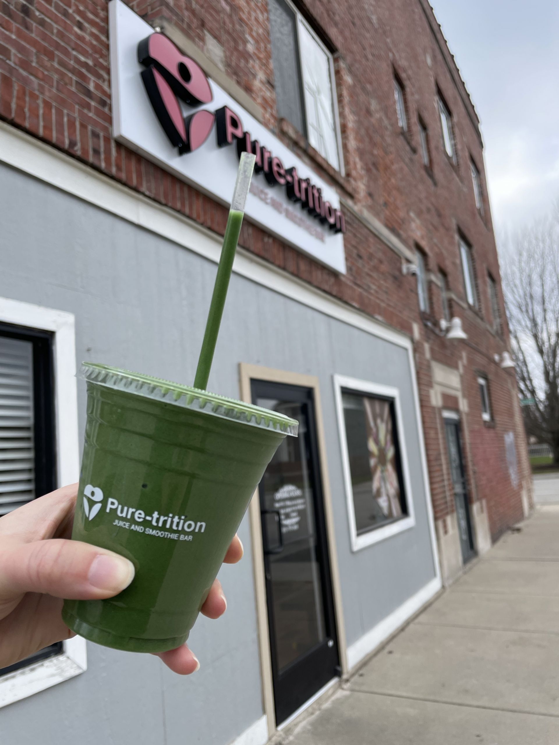 Pure-Trition Smoothie with building in background