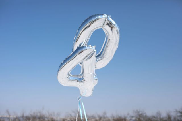 Silver number balloons "40" against blue sky.