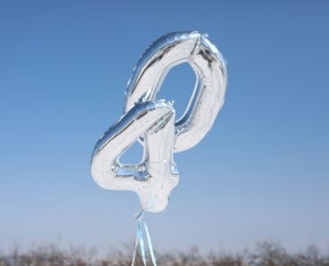 Silver number balloons "40" against blue sky.