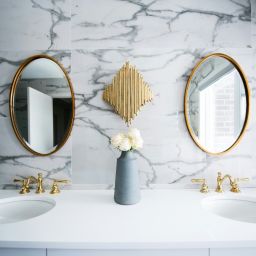 bathroom double sink and gold oval mirrors