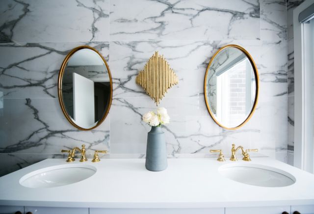 bathroom double sink and gold oval mirrors