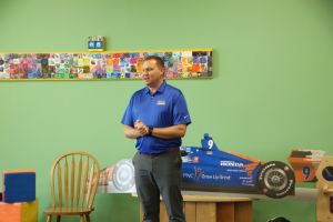 Andrew reading to kids in classroom with his 20th Anniversary shirt