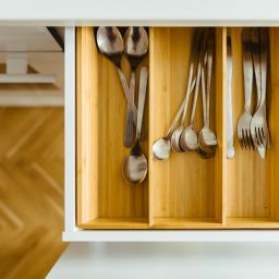Bamboo drawer organizers in a kitchen drawer with silverware