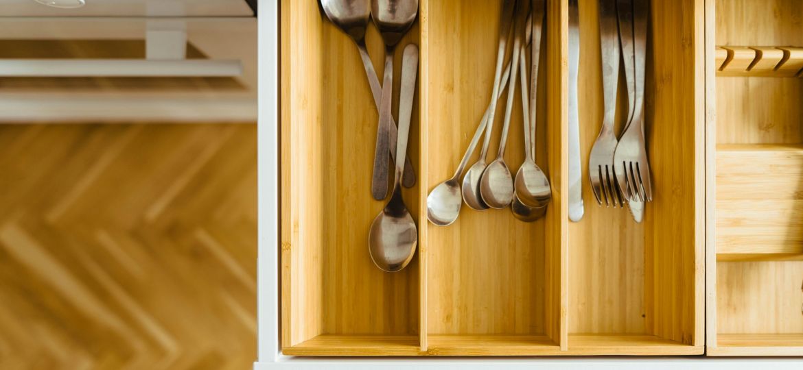 Bamboo drawer organizers in a kitchen drawer with silverware