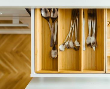 Bamboo drawer organizers in a kitchen drawer with silverware