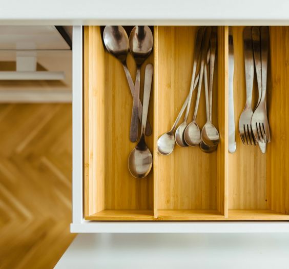 Bamboo drawer organizers in a kitchen drawer with silverware