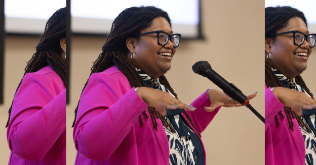 Tamara Winfrey-Harris, President of the Women's Fund of Central Indiana speaking at a microphone wearing a hot pink blazer