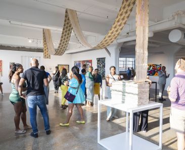 A small crowd gathering in a gallery at Butter 2023/photo cred. Eric Lubrick