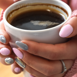 Black women's hands holding a cup of coffee