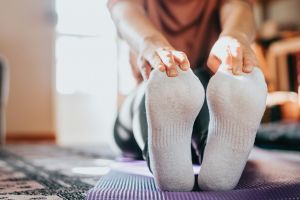 Person stretching and holding their feet.