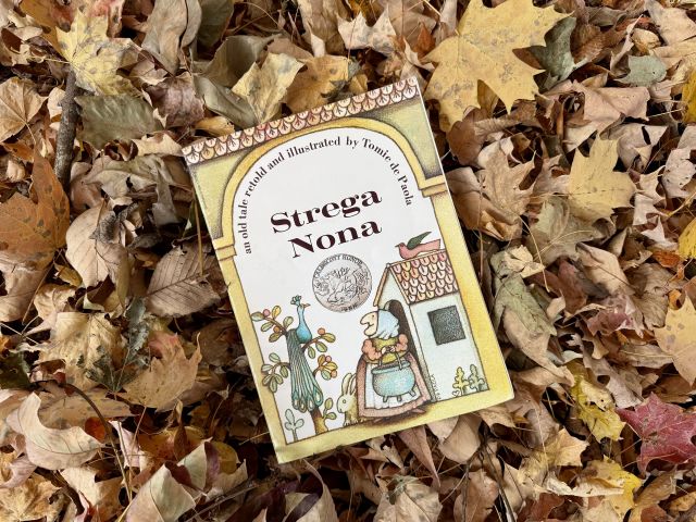 Strega Nona Book sitting on leaves.