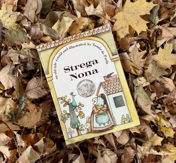 Strega Nona Book sitting on leaves.