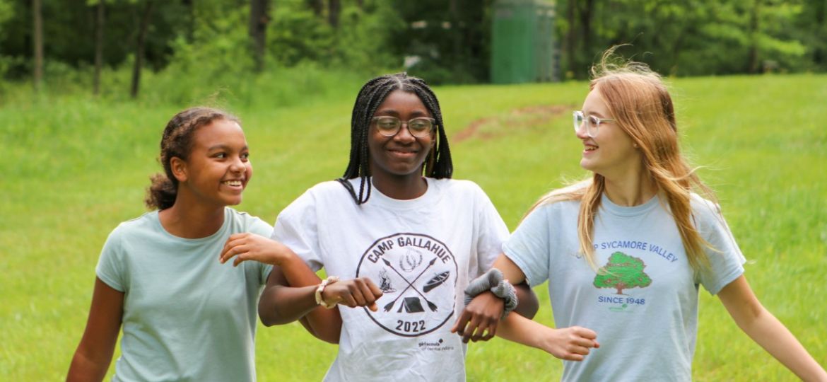 young women walking arm in arm