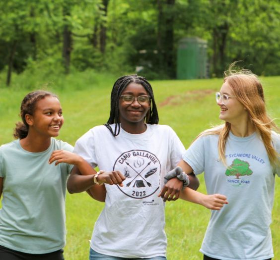 young women walking arm in arm