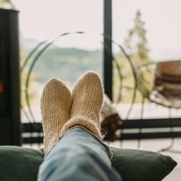 A person cozy and relaxing with a fireplace in the background.